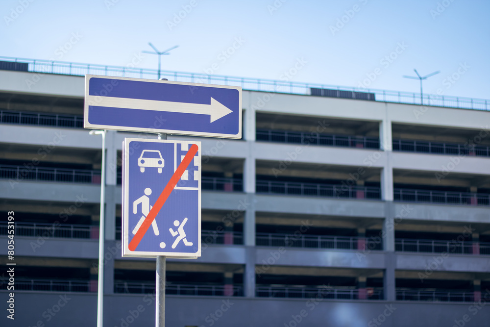 Obraz premium Skyblue and white sign directs right, showing way to building facade
