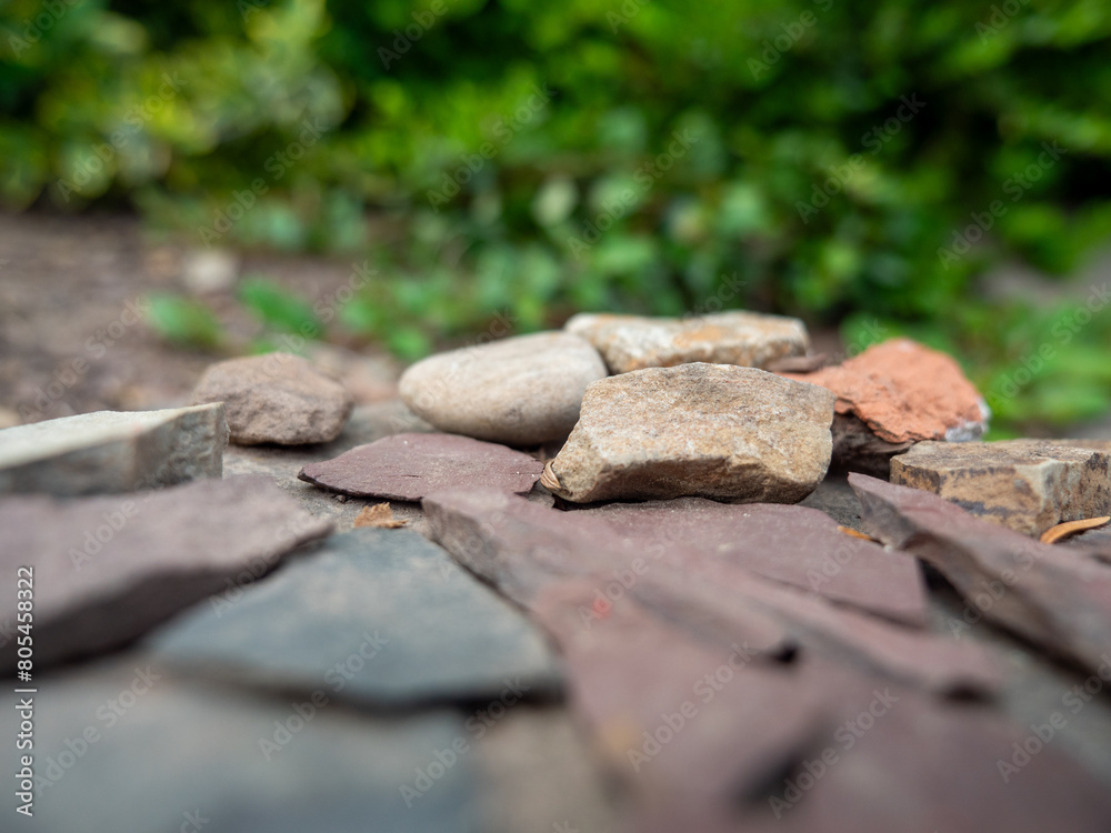 Various stones lying on the ground with a narrow plane of focus and green background Various stones lying on the ground with a narrow plane of focus and green background