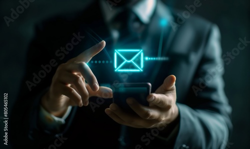 A man is holding a cell phone and pointing to an envelope on the screen