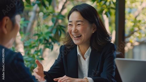 Japanese Businesswoman Engages in Serious Meeting Amidst Urban Greenery