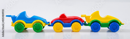Three plastic toy children's racing cars on a white background.