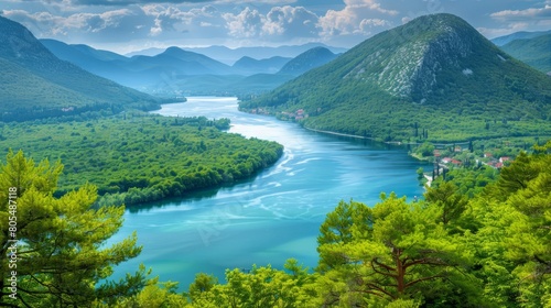  A river runs through a verdant valley, encompassed by lush green trees and towering mountains The sky above is a crisp blue canopy, dotted with fluffy white