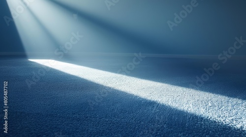   A room featuring a blue carpet, illuminated by a bright light at its far end photo