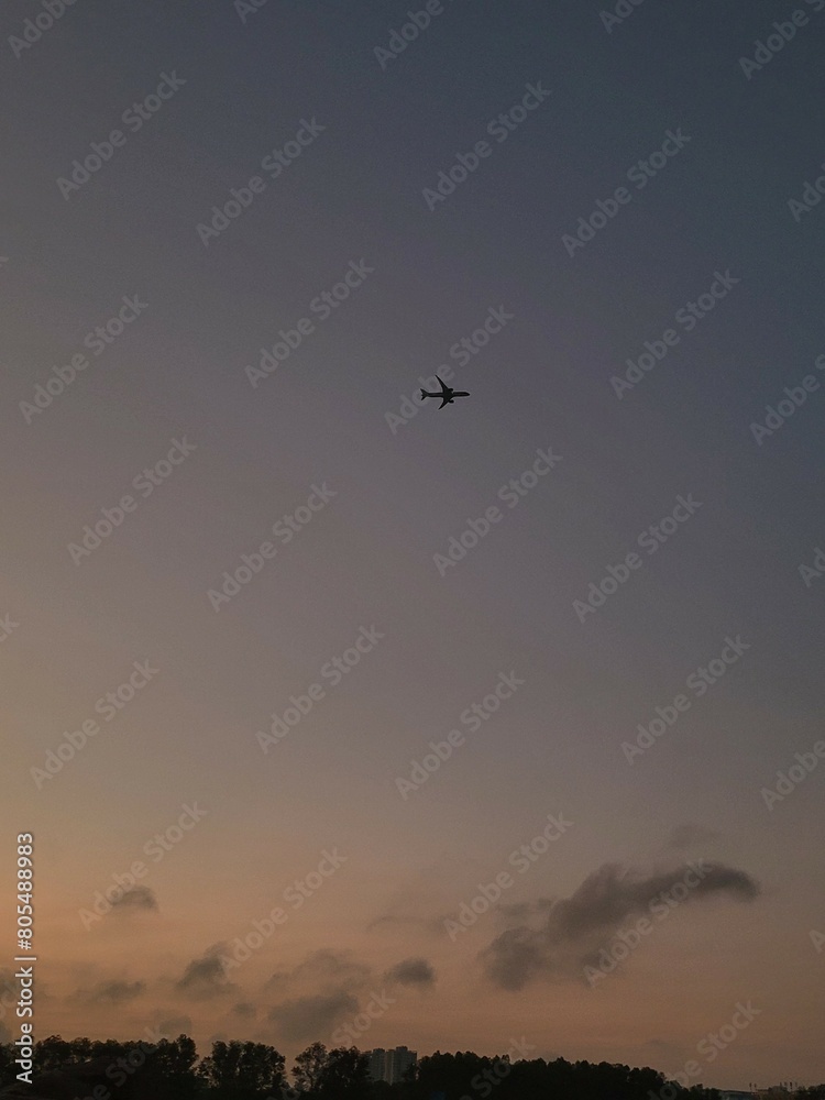 early morning sunrise, purple sky with an airplane