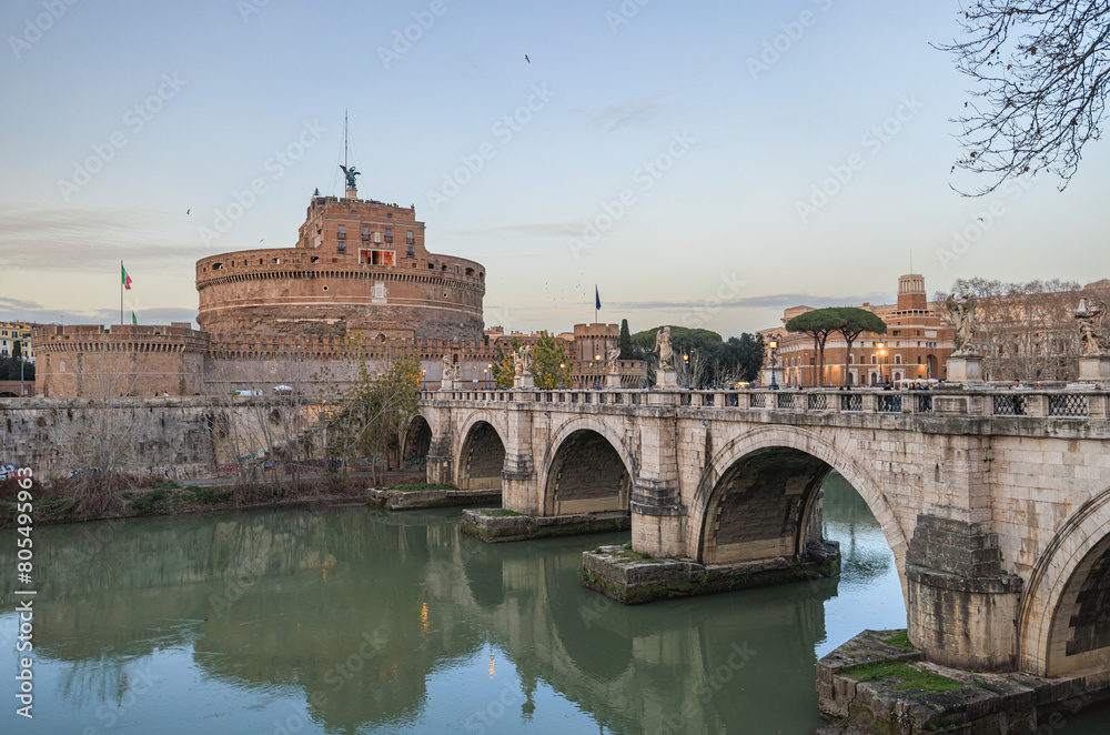 Obraz premium A beautiful bridge stretches over a serene river, leading towards a grand castle in the background. The scene is enchanting, with the castle standing tall against the sky