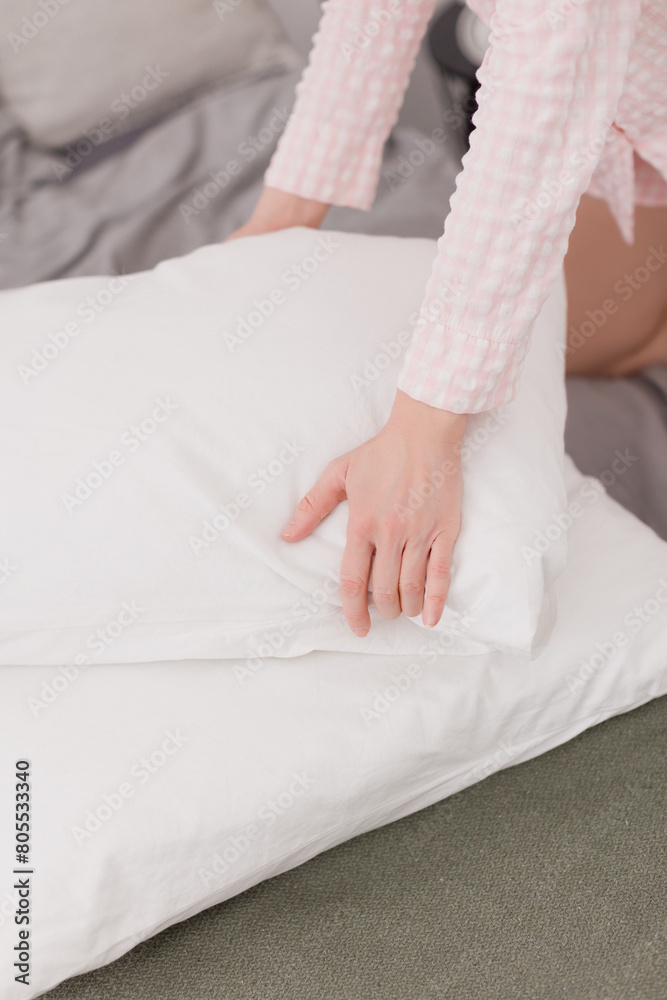 A woman changes bed linen