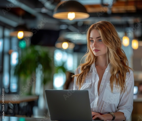 Caucasian businesswoman typing on modern laptop in office interior