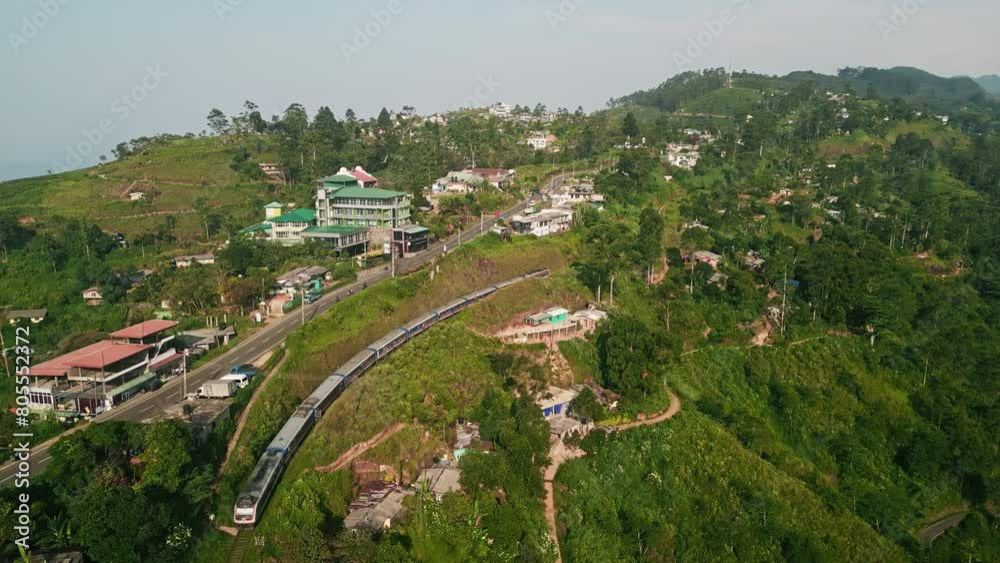 Aerial view of train snaking through rich Ceylon tea plantation. Scenic rail travel in Sri Lanka morning illuminates vibrant green landscape. Passengers experience unique journey tranquil nature. Aerial view of train snaking through rich Ceylon tea plantation. Scenic rail travel in Sri Lanka morning illuminates vibrant green landscape. Passengers experience unique journey tranquil nature.