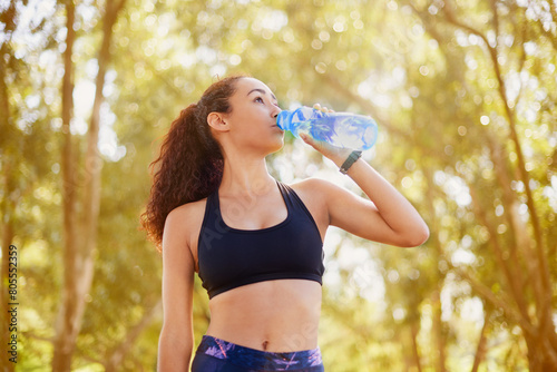 Nature, bottle and water for girl, fitness and hydration for training, workout and healthy with sports. Forest, drink and woman with liquid, break and exercise in weekend, outdoor and wellness