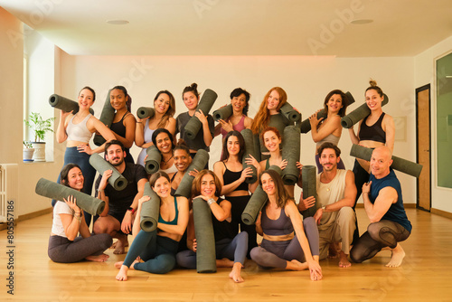 Obraz na płótnie A large group of people are posing for a photo with yoga mats. Scene is positive and energetic, as everyone is smiling and holding their mats. The idea of the image is to capture a moment of camarader w salonie