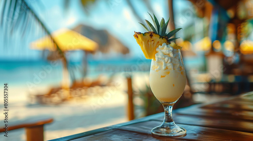 closeup photo of fresh cold alcoholic fruit pina colada cocktail drink glass with cream and pineapple with blurry tropical beach bar in the background