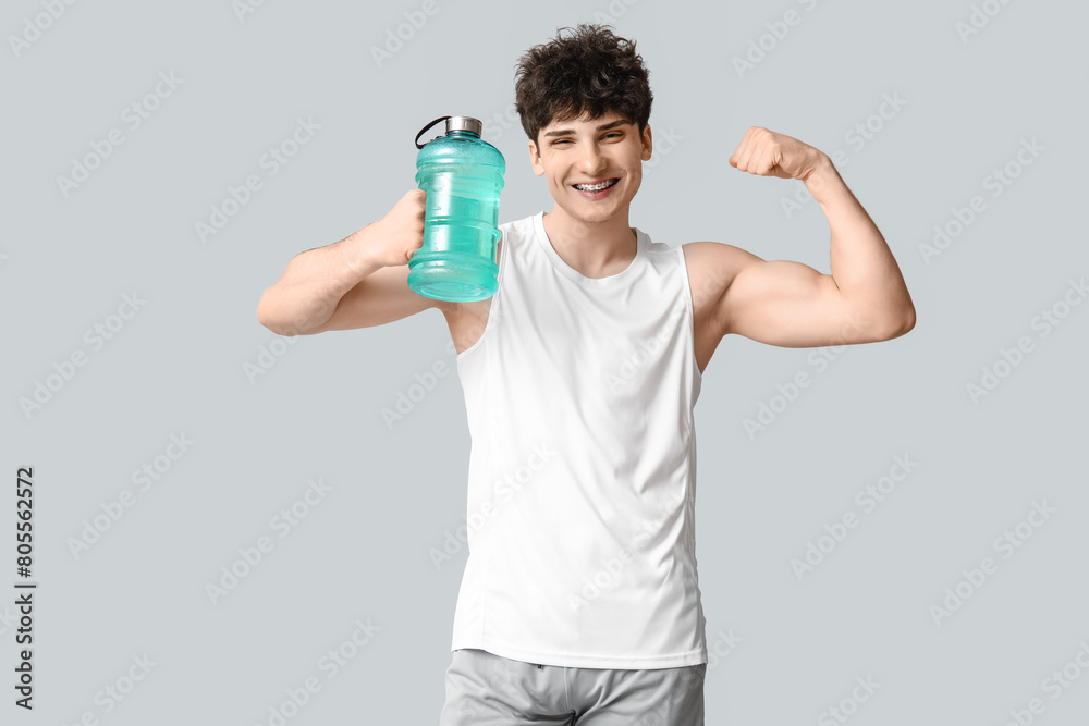 Sporty guy with bottle of water showing muscle on white background Sporty guy with bottle of water showing muscle on white background