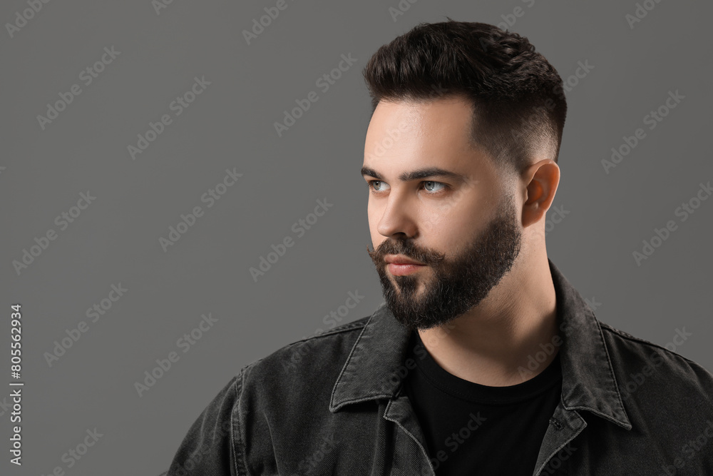 Portrait of young man with mustache on grey background. Space for text