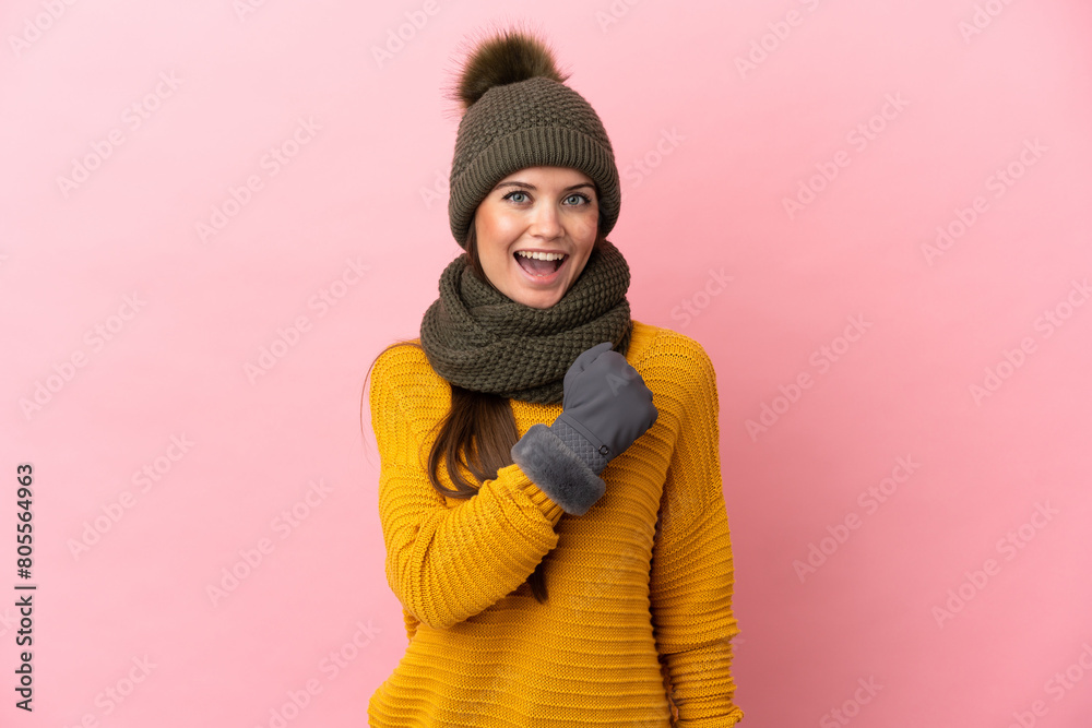 Young caucasian girl with winter hat isolated on pink background celebrating a victory Young caucasian girl with winter hat isolated on pink background celebrating a victory