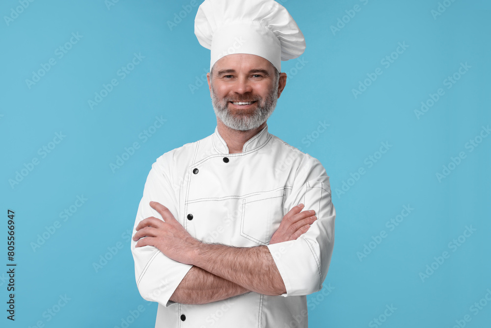 Happy chef in uniform on light blue background Happy chef in uniform on light blue background