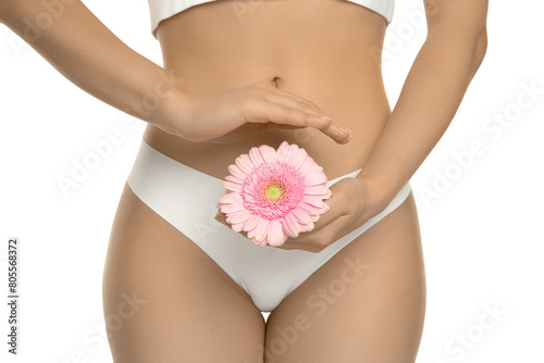 Gynecology. Woman in underwear with gerbera flower on white background, closeup