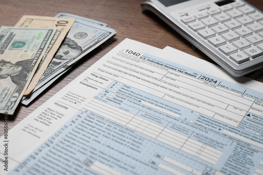 Obraz premium Payroll. Tax return forms, dollar banknotes and calculator on wooden table