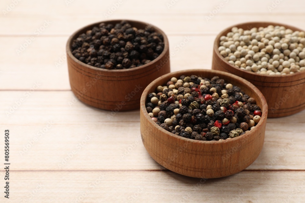 Aromatic spices. Different peppers in bowls on wooden table Aromatic spices. Different peppers in bowls on wooden table