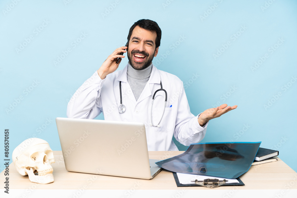 Professional traumatologist in workplace keeping a conversation with the mobile phone with someone Professional traumatologist in workplace keeping a conversation with the mobile phone with someone