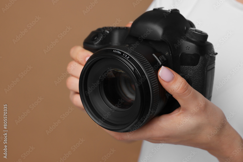 Photographer with camera on brown background, closeup Photographer with camera on brown background, closeup