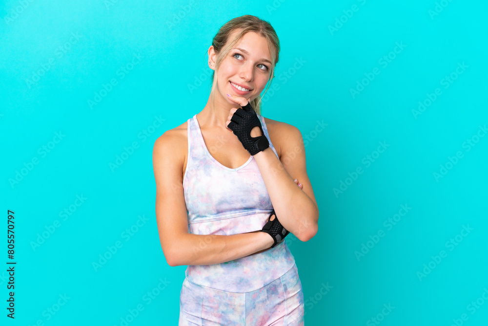 Sport caucasian woman isolated on blue background looking to the side