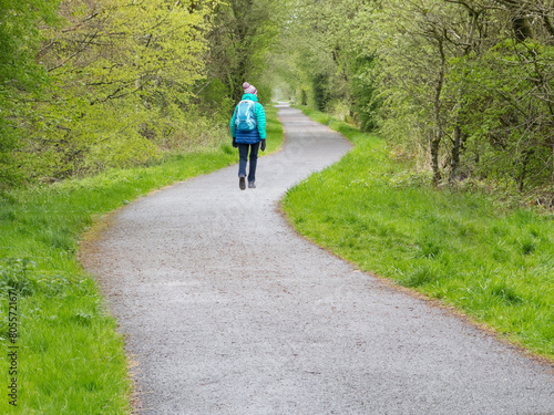 Elderly women walking alone on path in the countryside