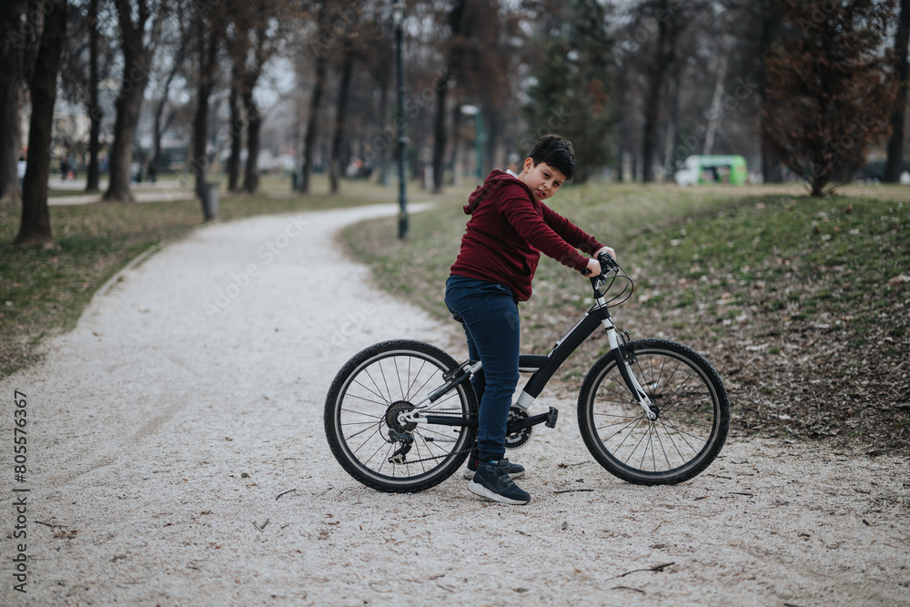 Carefree young boy riding his bicycle in a green park, a scene of healthy childhood lifestyle and joy. Carefree young boy riding his bicycle in a green park, a scene of healthy childhood lifestyle and joy.