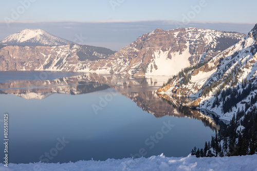 A beautiful mountain range with a lake in the background. The lake is calm and still, reflecting the mountains in its mirror-like surface. The scene is serene and peaceful © wollertz