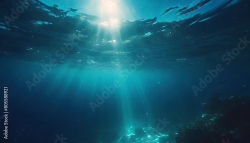 dark blue water of a deep sea with sun glare in the sky peaceful underwater landscape