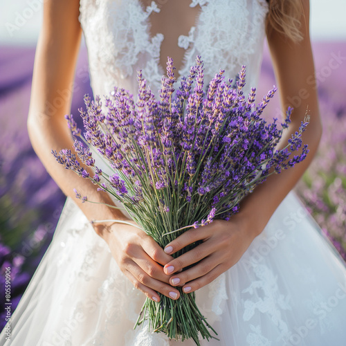 A bride holding a bouquet of lavender in a lavender field
