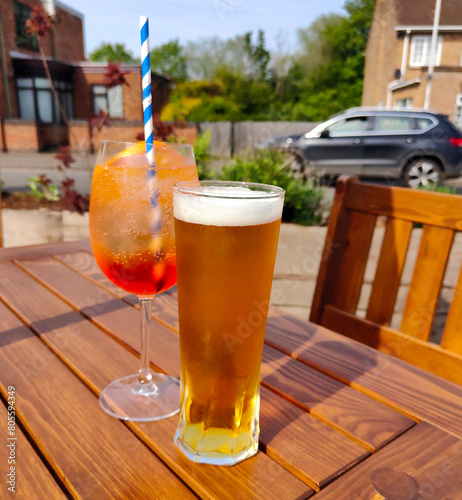 Couple of cold alcoholic drinks on a table in pub garden. © Mark