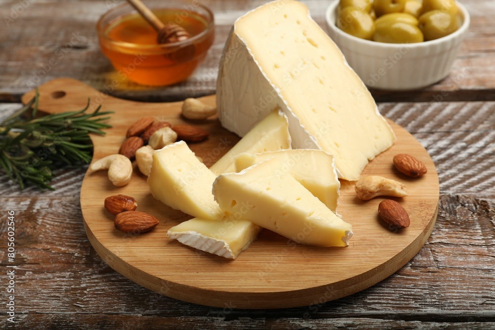 Tasty Camembert cheese with nuts on wooden table Tasty Camembert cheese with nuts on wooden table