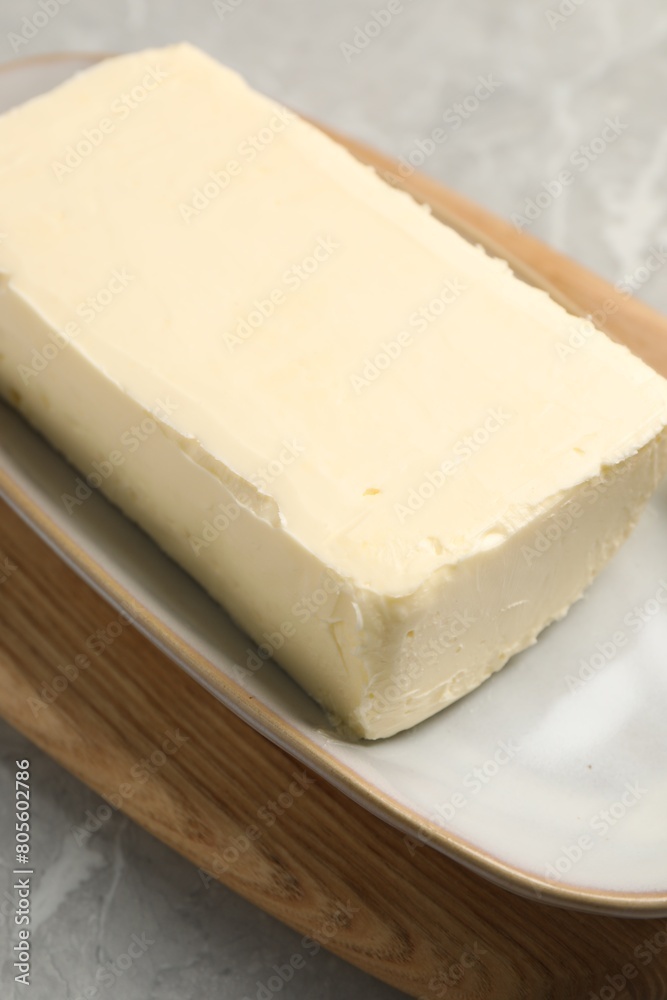 Block of tasty butter on grey table, closeup