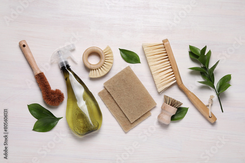 Flat lay composition with different cleaning supplies on light wooden background