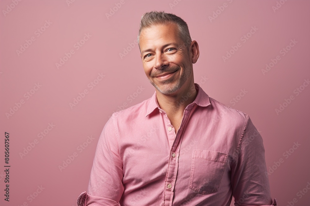 A man in a pink shirt is smiling and looking at the camera A man in a pink shirt is smiling and looking at the camera