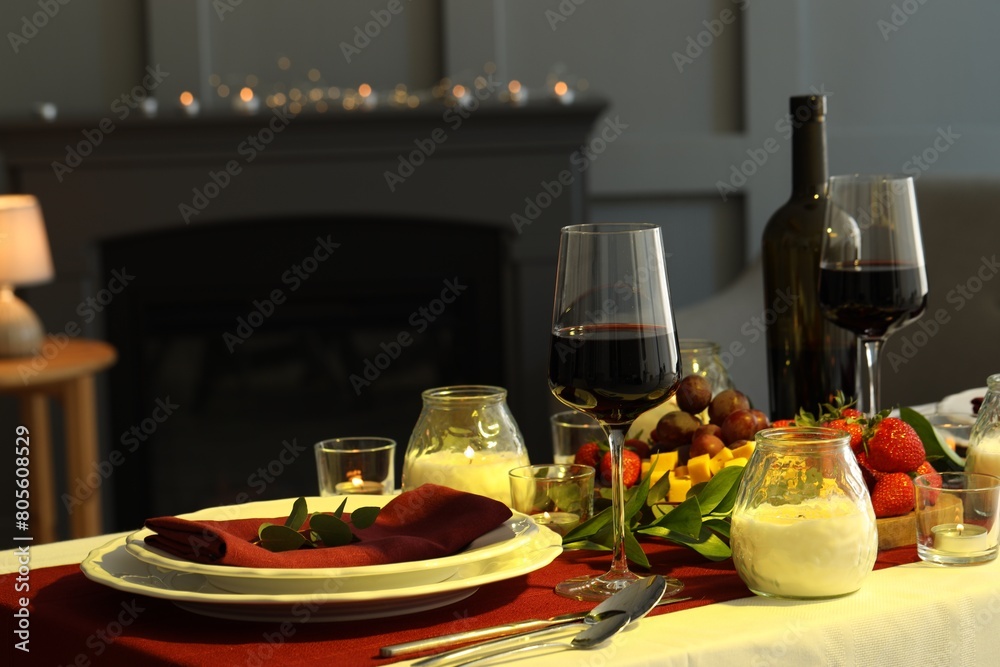 Naklejka premium Stylish table setting with burning candles and wine indoors. Romantic dinner