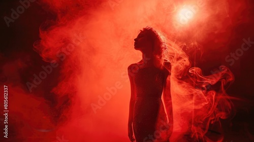 Actress with red theater light, red smoke, red effect created with theatrical lighting equipment and a smoke machine.