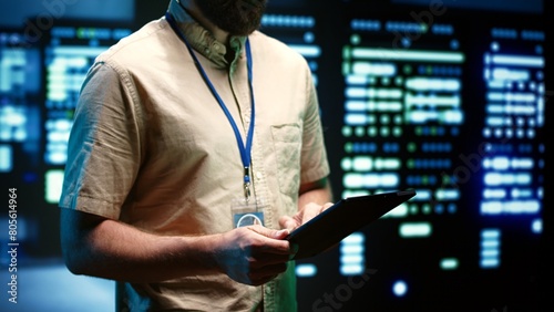 Фотография Experienced engineer inspecting operational server racks in computer network security data center