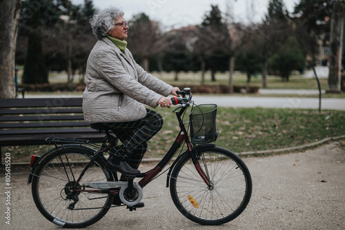 Mature woman enjoying her retirement with a leisurely bicycle ride in a serene park setting.