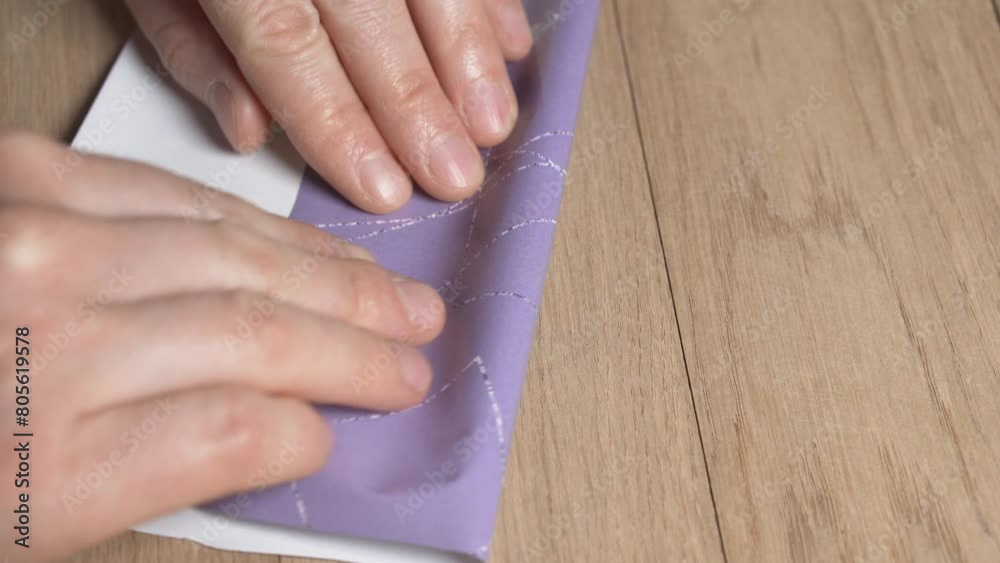 Women's hands pack an ampoule of medicine in wrapping paper. Women's hands pack an ampoule of medicine in wrapping paper.