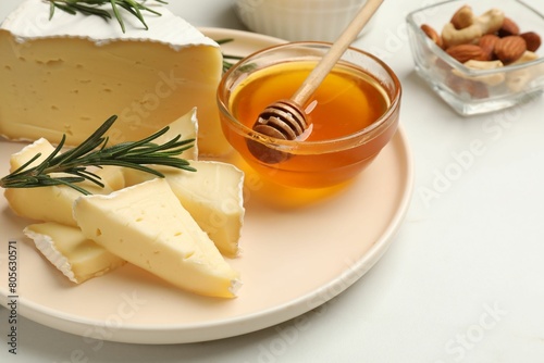 Tasty Camembert cheese with rosemary and honey on white table, closeup