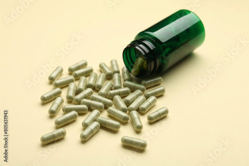 Vitamin pills and bottle on beige background