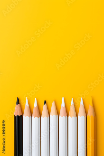 Template with copy space by top view closeup macro photo of wooden yellow pencil put on yellow paper that look minimal and clean. Side flash light made difference between them by highlight and shadow.
