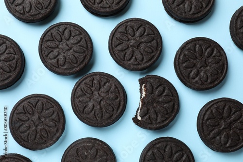 Tasty sweet sandwich cookies on light blue background, flat lay