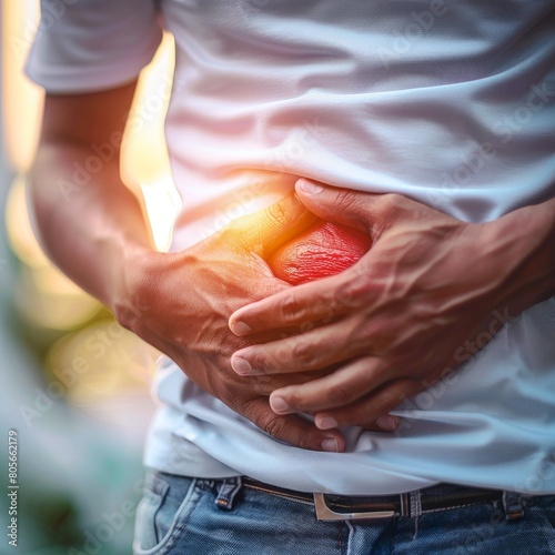 Closeup of a person holding their stomach with a red pain area highlighted, blurred background showing a medical professional