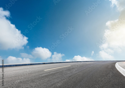 Modern highway cutting through the countryside under a clear blue sky