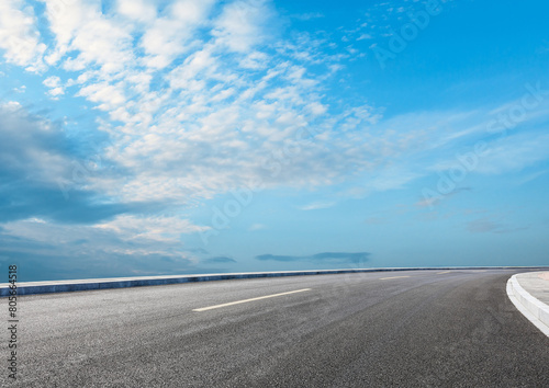 Modern highway cutting through the countryside under a clear blue sky