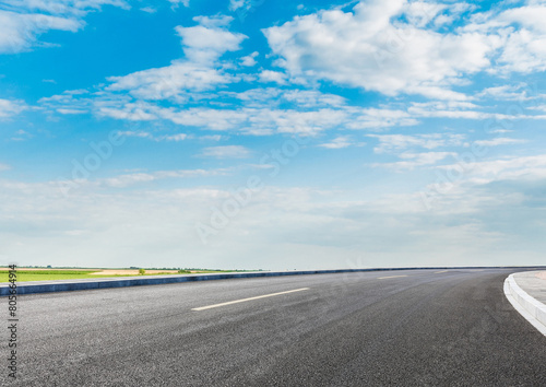 Modern highway cutting through Asian countryside under a clear blue sky