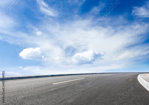 Modern highway cutting through Asian countryside under a clear blue sky