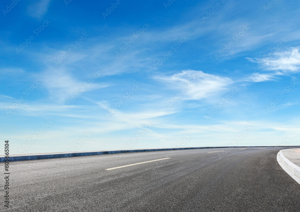 Modern highway cutting through Asian countryside under a clear blue sky